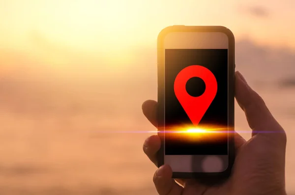 네비게이터 GPS 위치 아이콘 일몰 해변 배경에 검은 스마트 폰을 사용하여 우주 남자 손을 복사합니다. 여행 모험 라이프 스타일 및 비즈니스 경제 개념. — 스톡 사진