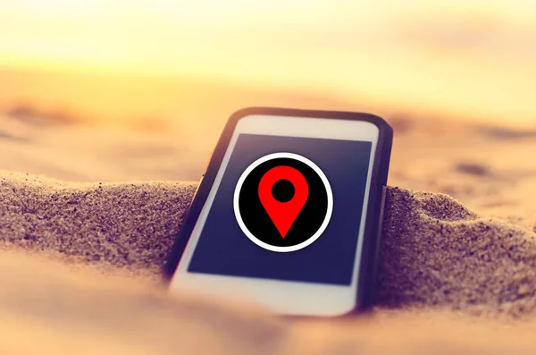 빨간 네비게이터 GPS 위치 추상적 인 배경스마트 폰과 모래 일몰 해변. 기술 여행 휴가 및 비즈니스 온라인 개념의 복사 공간. — 스톡 사진