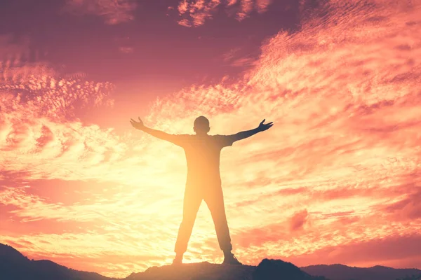 Kopiëren van de ruimte van de man aanleiding hand omhoog bovenop de berg en abstracte achtergrond van avondrood. — Stockfoto