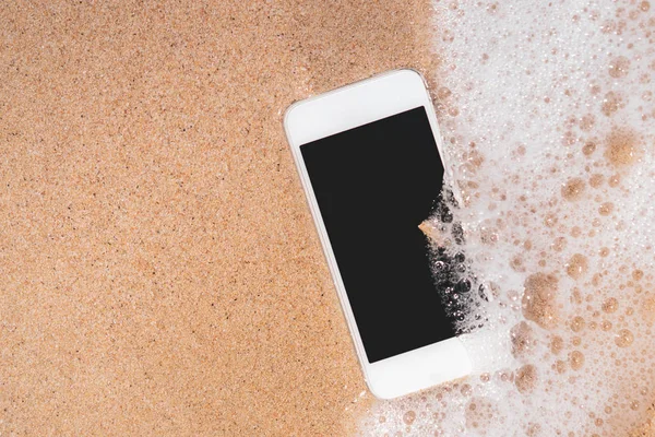 Chytrý telefon na pískové pláži textury pozadí. — Stock fotografie