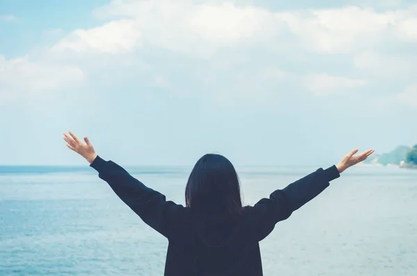 Copy space of woman rise hand up on blue sky at tropical beach and island background.