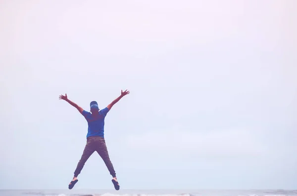 Glücklicher Mann, der am tropischen Sandstrand springt. Freiheit zum Wohlfühlen und Sommerferienkonzept. — Stockfoto
