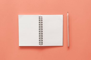 Pastel renk dokusu arkaplanındaki defter ve kalem.