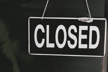 Kafe ayna kapısının önünde kapalı tabela asılı. İş hizmeti ve yiyecek içecek konsepti. Klasik ton filtre efekti renk biçimi.