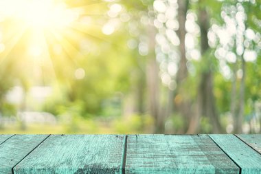 Görüntü parkı ve yeşil doğa bokeh yaprağı fotokopi uzayı üzerinde güneş ışığı olan boş eski ahşap masa soyut arka plan. Taze doğada ürün sunumu. Ekoloji ortamı ve doğa kavramı.