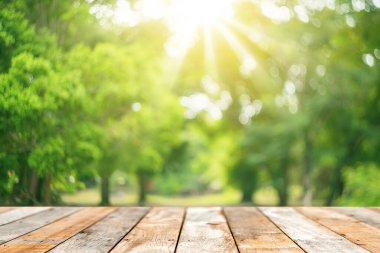 Görüntü parkı ve yeşil doğa bokeh yaprağı fotokopi uzayı üzerinde güneş ışığı olan boş eski ahşap masa soyut arka plan. Taze doğada ürün sunumu. Ekoloji ortamı ve doğa kavramı.