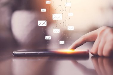 Kahve dükkanında soyut arka planda uçan e-posta ikonu olan akıllı telefon kullanan bir kadın. Teknoloji sektörü ve serbest meslek kavramı. Klasik ton filtre efekti renk biçimi.