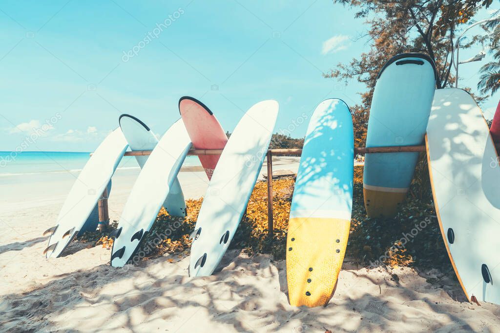 Surfboard on tropical beach with blue sky background. Summer vacation and sport extreme concept. Vintage tone filter effect color style.