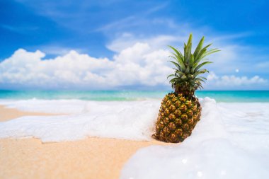 Tropik plaj arka planında ananas. Yaz tatili ve sağlıklı gıda konsepti.