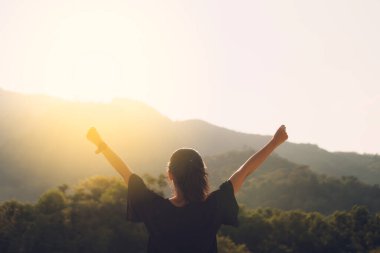 Silüet kadının kopyalanmış uzayı dağın tepesinde ve günbatımında gökyüzü soyut arkaplanı bulutlandırıyor. Özgürlük iyi hissettiriyor ve seyahat macerası tatili konsepti. Klasik ton filtre efekti renk biçimi