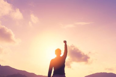 İnsan elinin dağın tepesine yükselişini ve günbatımı gökyüzünün soyut arkaplanını kopyala. Özgürlük yolculuğu macerası ve iş zaferi kavramı. Klasik ton filtre efekti renk biçimi.