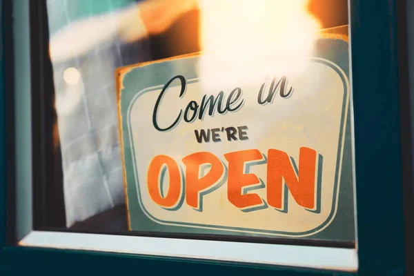 Open sign hanging front of cafe with colorful bokeh light abstract background. Business service and food concept. Vintage tone filter effect color style.