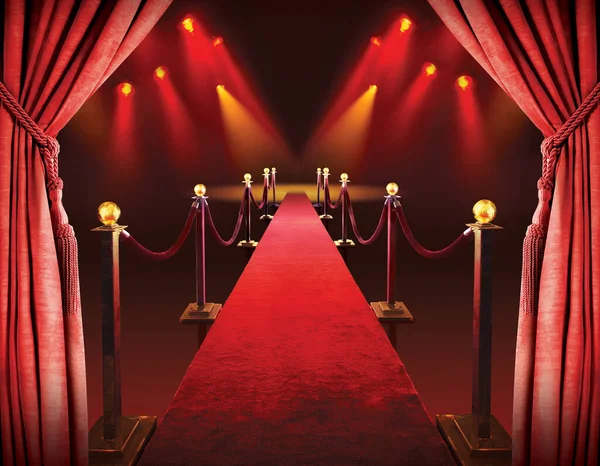 Kırmızı halı girişi bariyerler, kadife ipler ve arka planda ışıklar.