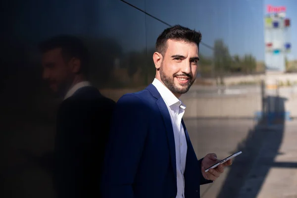Portrait of a young executive with suit and cell phone