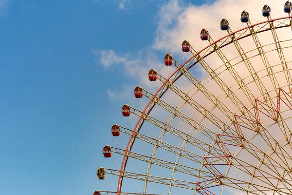 Amusement park giant wheel against blue sky background