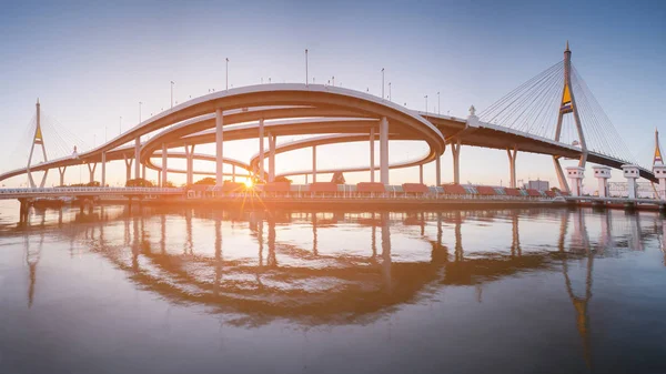 Sunset over twin bridge and highway intersection clear blue sky background