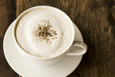 ahşap zemin üzerinde beyaz fincan cappuccino kahve
