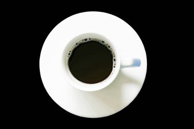 Bir fincan kahvenin üst görüntüsü, siyah arkaplanda izole edilmiş.