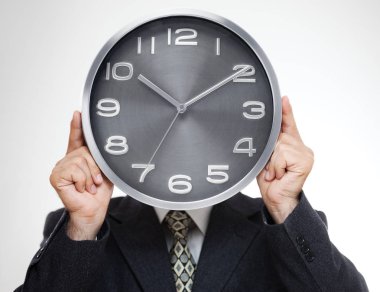 Analog saat gri arka plan üzerinde izole ile yüzünü kaplayan işadamı yakın çekim