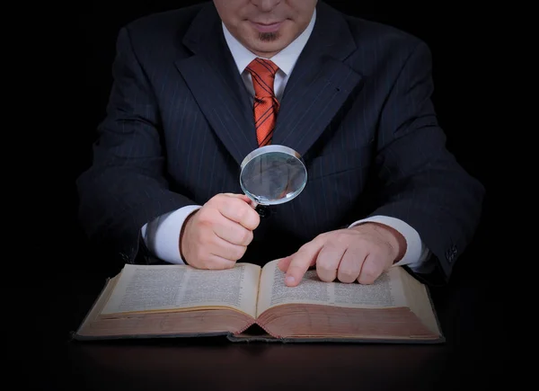 işadamı balck arka plan üzerinde büyüteç kullanarak