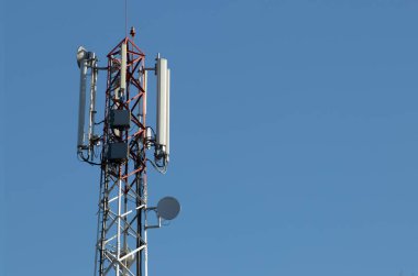 Arkasında mavi gökyüzü olan telekomünikasyon kulesi.