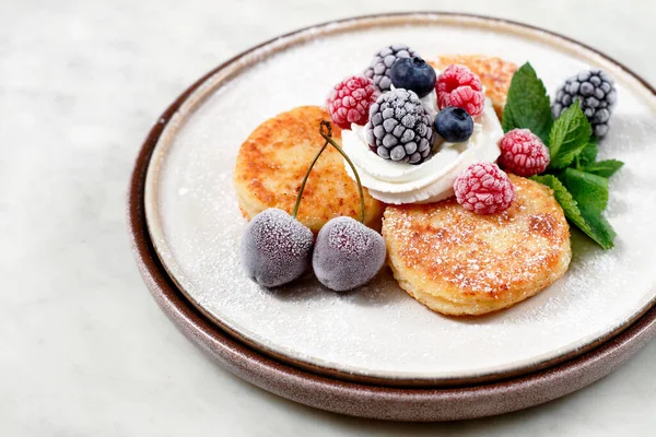 cheese pancake with berries, frozen berries, chees pancake, cottage cheese, on a white table, horizontal, breakfast,