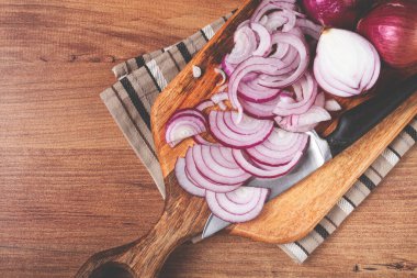 Kesme tahtasında dilimlenmiş kırmızı soğan, bir bıçakla, İspanyol soğanı, çiğ soğan, yakın plan, üst görünüm,