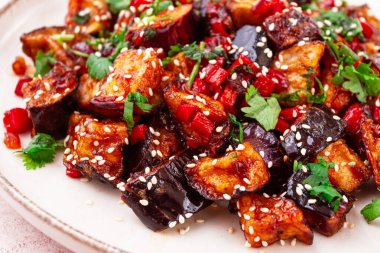Kızarmış patlıcan, Çin usulü, tatlı ve ekşi soslu, biberli ve susamlı. Beyaz bir tabakta,
