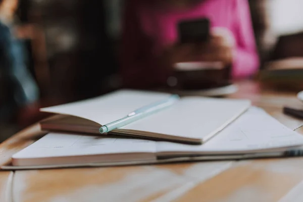 Close Notebooks Com Caneta Mesa Com Mulher Segurando Smartphone Segundo — Fotografia de Stock