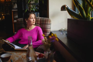 Kahvede dinlenirken, elinde menü tutan gülümseyen bayanın belini kaldırın.