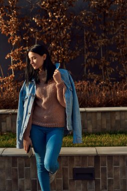 Bir meydanın sessiz ve huzurlu bir köşesinde tek bacağının üzerine yaslanmış duran ve aşağı bakan sevimli bayan.