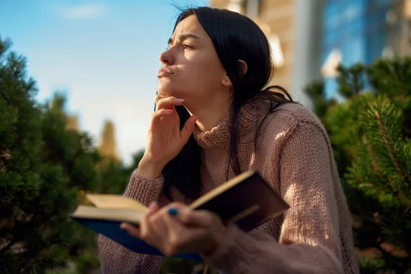 Jovencita Concentrada Sentada Cerca Una Conífera Patio Sosteniendo Libro Abierto — Foto de Stock