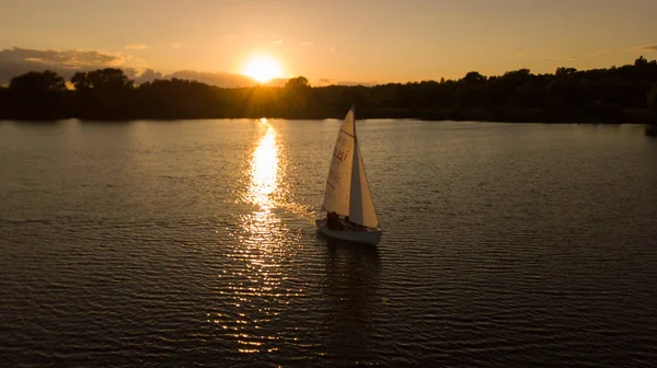 Sunset on the lake with small sailboat