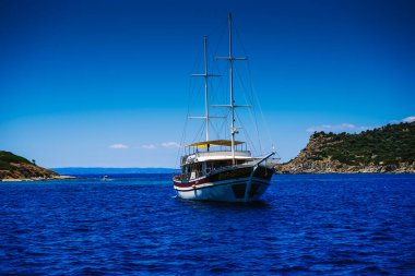 İki direkli bir yat denizin, okyanusun ve gölün körfezine demir atmış. Bir yatta dinlen. Yelkenli. Deniz yatında bir tatil. Akdeniz yaz manzarası. Deniz tutması.