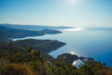 Dağdan, Akdeniz 'in güzel koylarına bakın. Batan güneşin yansıması - ay yolu. Yunanistan, Halkidiki, Pyrgadikia.