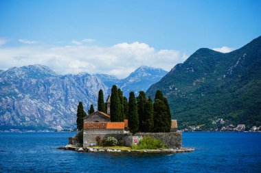 Dağ gölü manzarası, dağlar, eğlence yatları. Gölün ortasında bir ada. Kotor ve Perast 'ın bulunduğu kayalık kıyılarda bulunan fiyort benzeri ünlü körfez. Boko Kotor Koyu, koy.