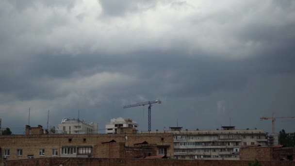 Rápidamente fluye gris, nubes siniestras sobre edificios de apartamentos con grúas de construcción en movimiento. Cronograma . — Vídeos de Stock
