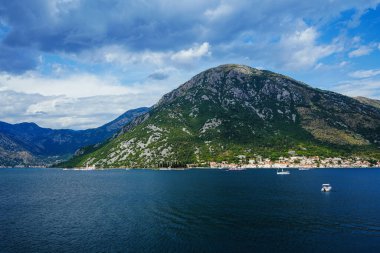 Dağ gölü manzarası, dağlar, eğlence yatları. Gölün ortasında bir ada. Kotor ve Perast 'ın bulunduğu kayalık kıyılarda bulunan fiyort benzeri ünlü körfez. Boko Kotor Koyu, koy.