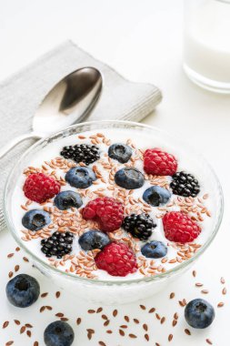 Yaban mersinli yoğurt, ahududu, böğürtlen, keten tohumu ve bir bardak süt. Vejetaryen yemeği. Sağlıklı kahvaltı, sağlıklı yemek..