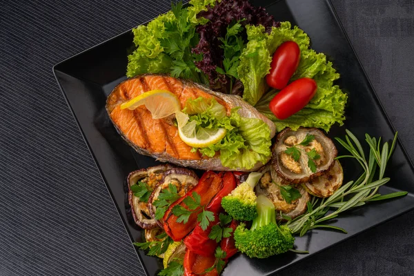 Restoranda yemek servisi yap. Yiyecek posteri - büyük porsiyon kırmızı balık, alabalık, ızgara sebzeli somon bifteği, salata, brokoli ve domates, limon ve biberiyeyle süslenmiş. Izgara sebze: patlıcan, kabak, Bulgar kırmızı biberi. Servis devam ediyor 