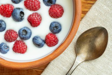 Yaban mersinli yoğurt, ahududu, böğürtlen, keten tohumu ve bir bardak süt. Vejetaryen yemeği. Sağlıklı kahvaltı, sağlıklı yemek. Restoran ve kafe menüsü için arkaplan.