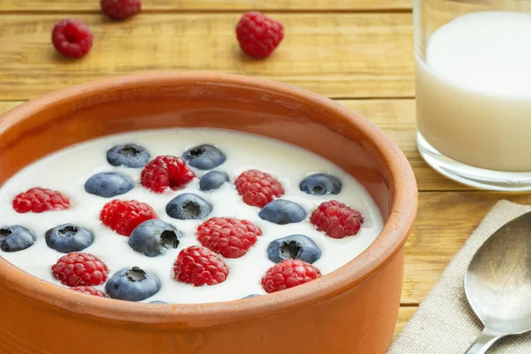 Yaban mersinli yoğurt, ahududu, böğürtlen, keten tohumu ve bir bardak süt. Vejetaryen yemeği. Sağlıklı kahvaltı, sağlıklı yemek. Restoran ve kafe menüsü için arkaplan.
