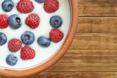 Yaban mersinli yoğurt, ahududu, böğürtlen, keten tohumu ve bir bardak süt. Vejetaryen yemeği. Sağlıklı kahvaltı, sağlıklı yemek. Restoran ve kafe menüsü için arkaplan.