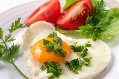 Sağlıklı ve sağlıklı bir kahvaltı. Yağda yumurta, domates, otlar ve espresso kahvesi. Keten peçete ve çatal bıçakla beyaz bir masada servis edilmiş. En sevdiğim sahanda yumurtayla tanışın: Kızarmış zeytinyağı yumurtası. Bu sahanda yumurtalar altın, dantelli ve çıtır çıtır.