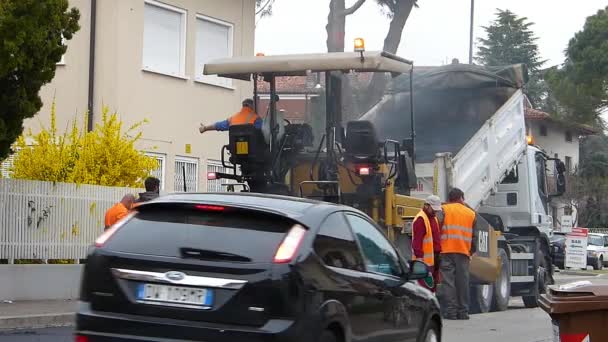 ウーディネ イタリア 2017 建設中の都市道路 進行中のアスファルト 青とオレンジのユニフォームでシャベルを持つ労働者 — ストック動画