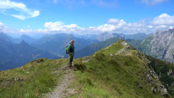 幸福の男ハイカー 太陽の光の下で夏晴れた日に山の頂上を歩く観光客 美しい山々の風景 — ストック動画