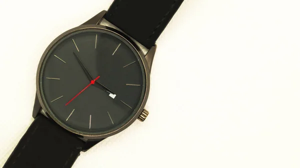 白い背景に赤い矢印を持つブラックメンズ腕時計。数字のない時計。メンズアクセサリー。テキスト用の場所。トップ表示. — ストック写真