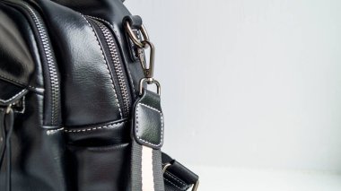 Arka planda siyah bir çanta. Kadın çantasında kilit ve kayış. Şık bir görünüm için bir aksesuar. Kadınların çantaları, sırt çantaları. Üstü açık çanta. Seçici odak.