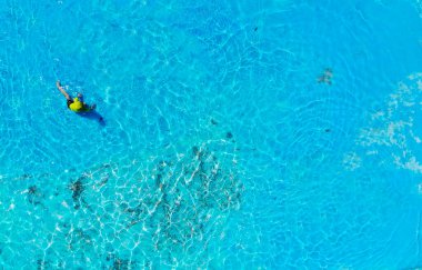 Havada eğlenen ve havuzda oynayan bir çocuğun fotoğrafı.