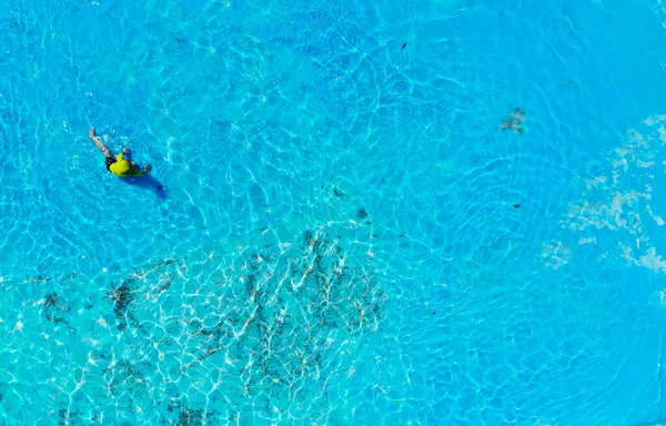 Havada eğlenen ve havuzda oynayan bir çocuğun fotoğrafı.